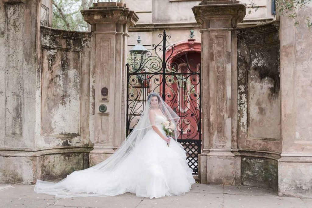 brunette bride poses in front of estate Charleston Wedding Photography Blog