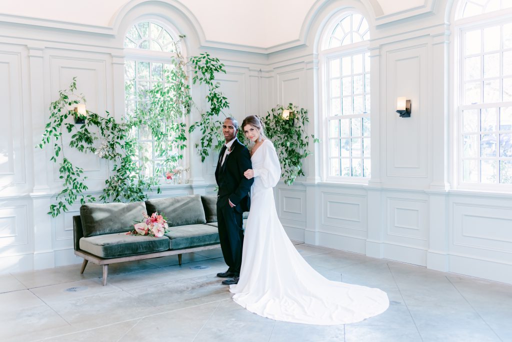 bride holding onto groom's arm inside I'on Chapel