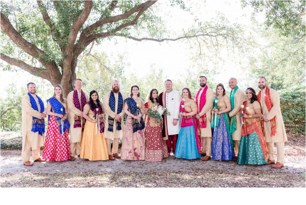 large colorful Indian wedding party posing outside