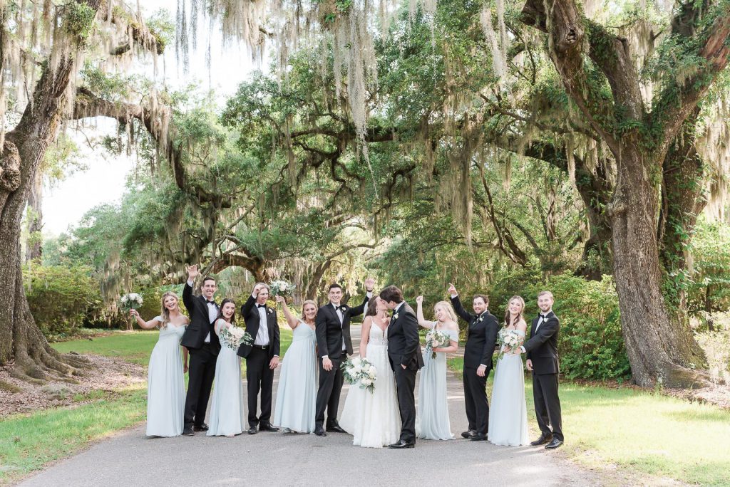 wedding party pose under avenue of oaks