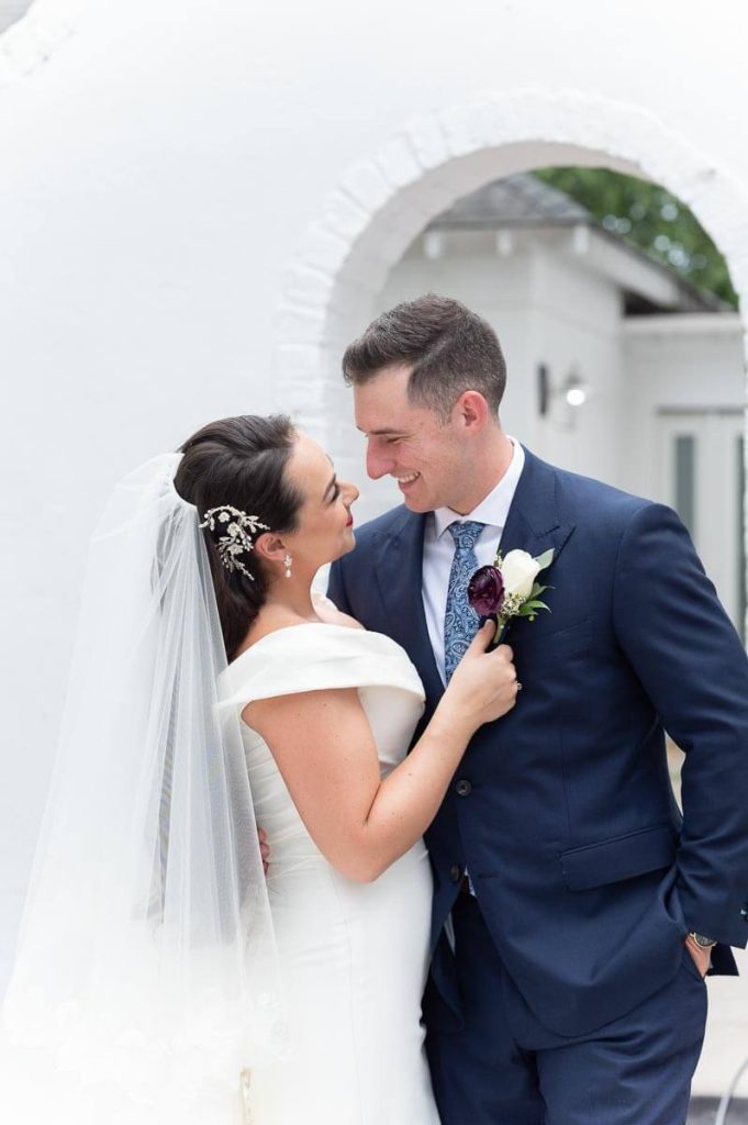 bride pulls in groom for kiss under arch