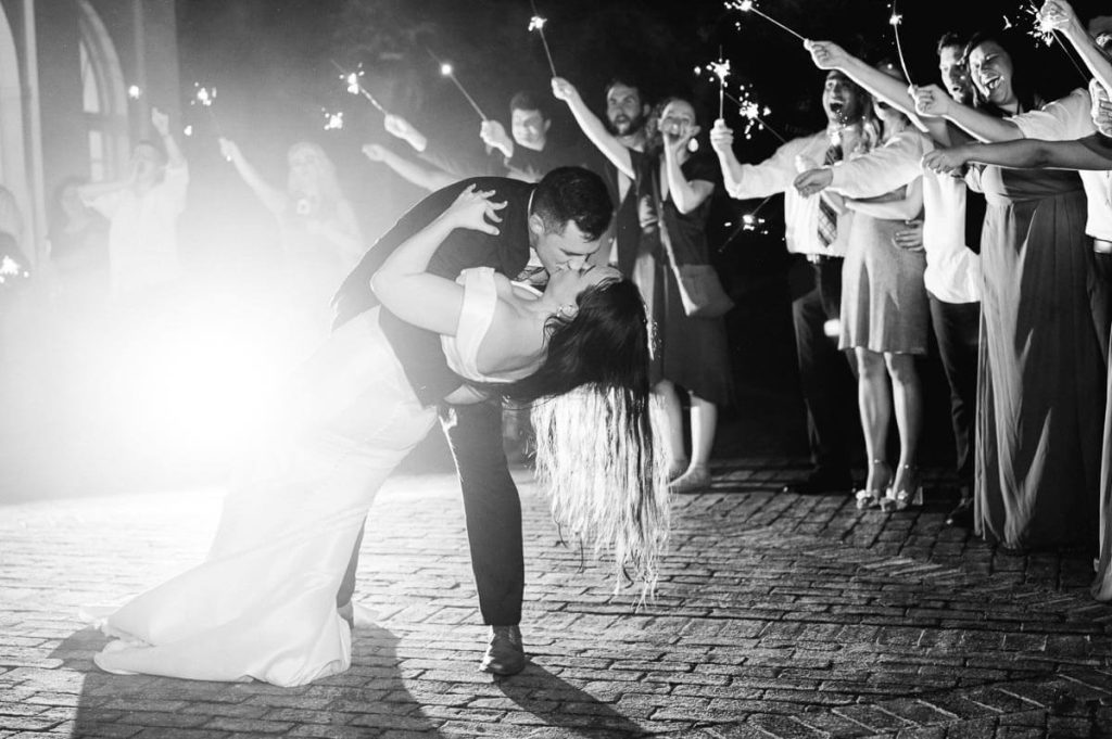newlyweds dip and kiss at sparkler send off
