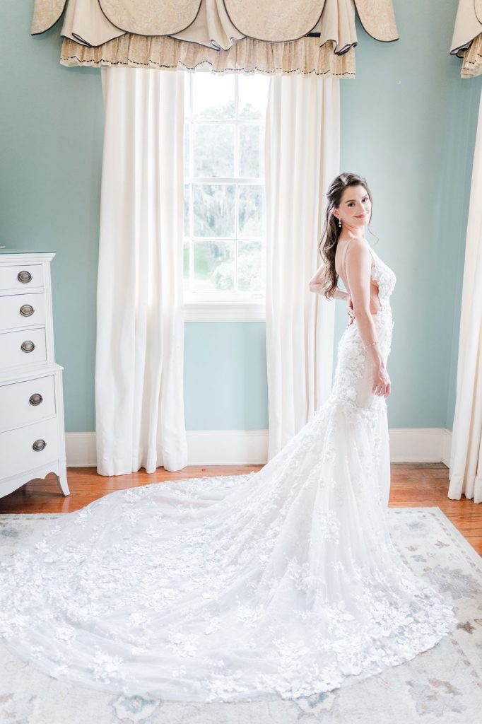 bride with hand on hip inside aqua room