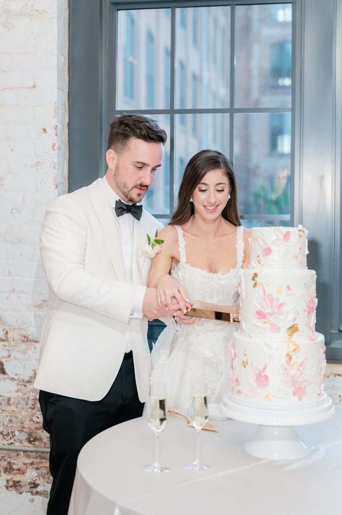 newlyweds cut three tiered wedding cake