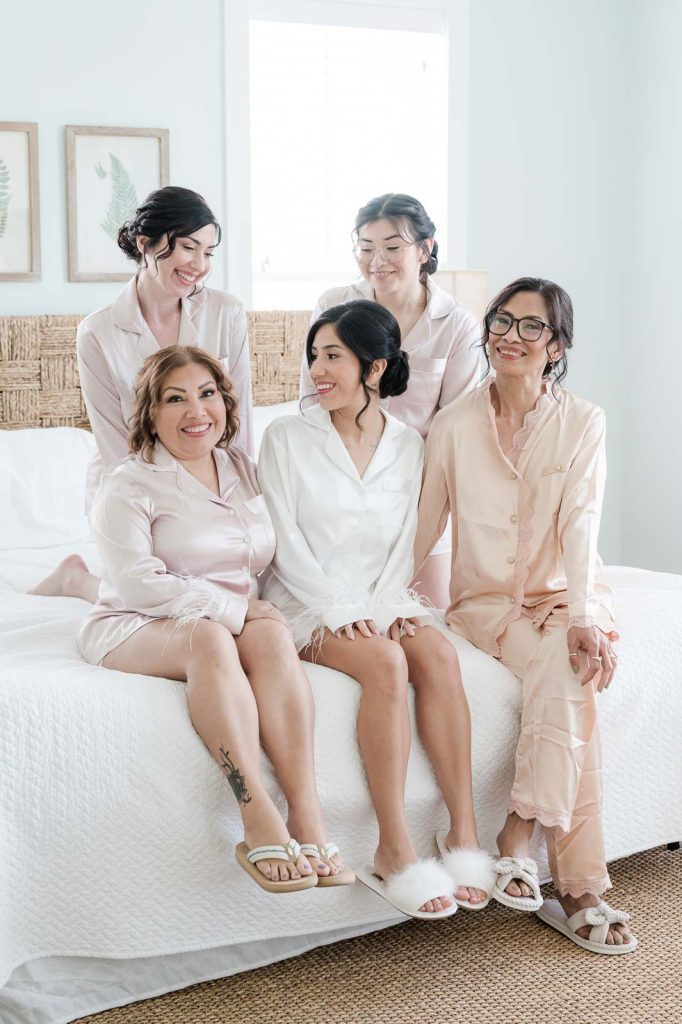 bridal party sitting on bed in pajamas