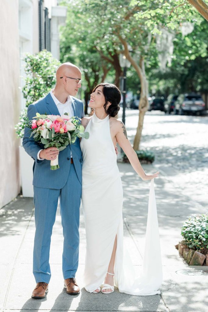 newlywed portrait of couple walking on cobblestone street