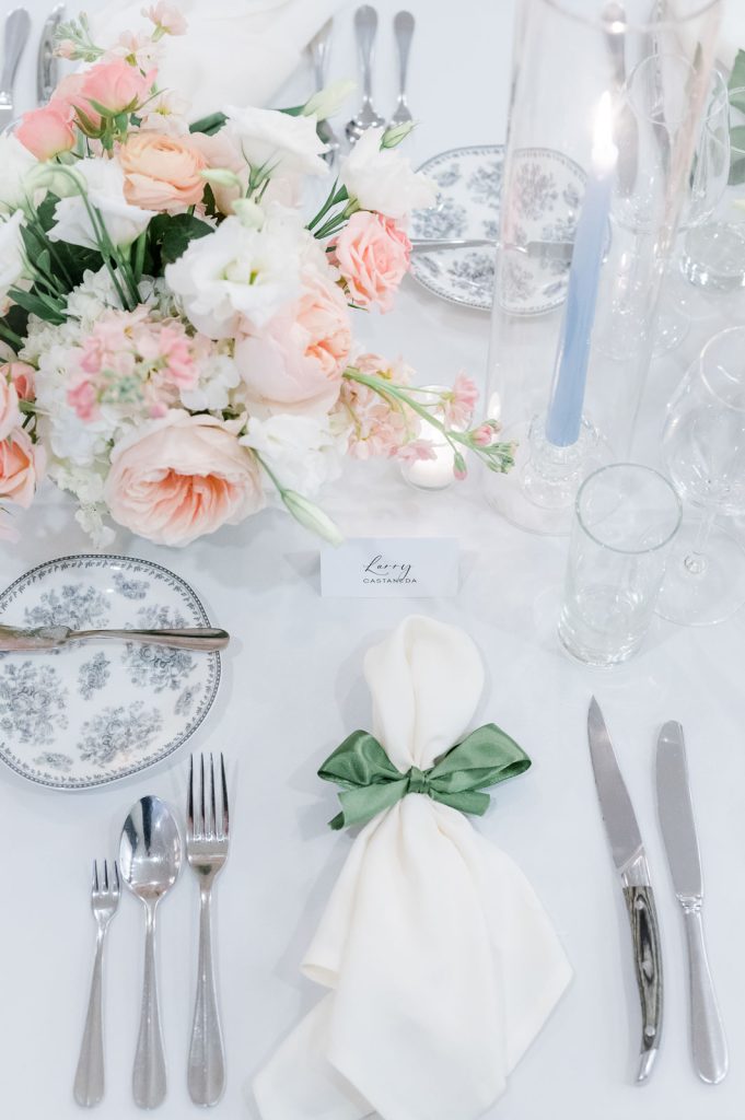 Place setting at wedding reception with blush flowers and blue candle