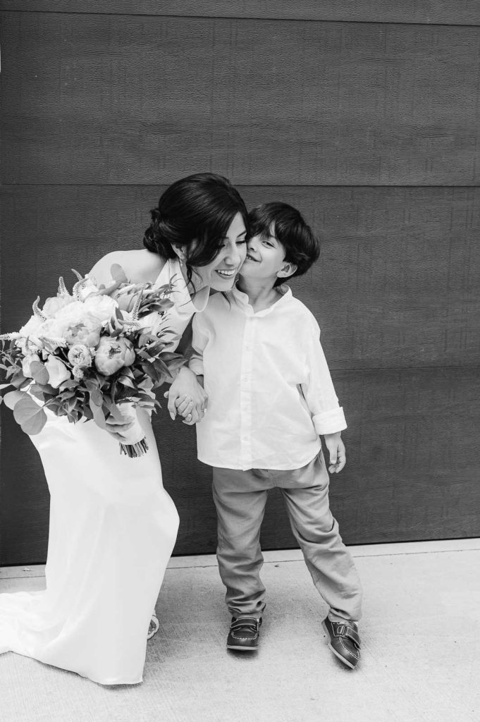 son kisses mother and bride on the cheek