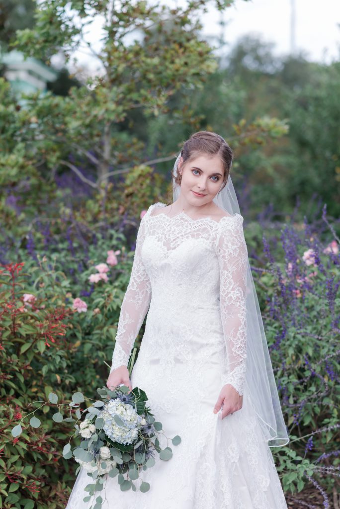 bride posing in garden full of flowers
