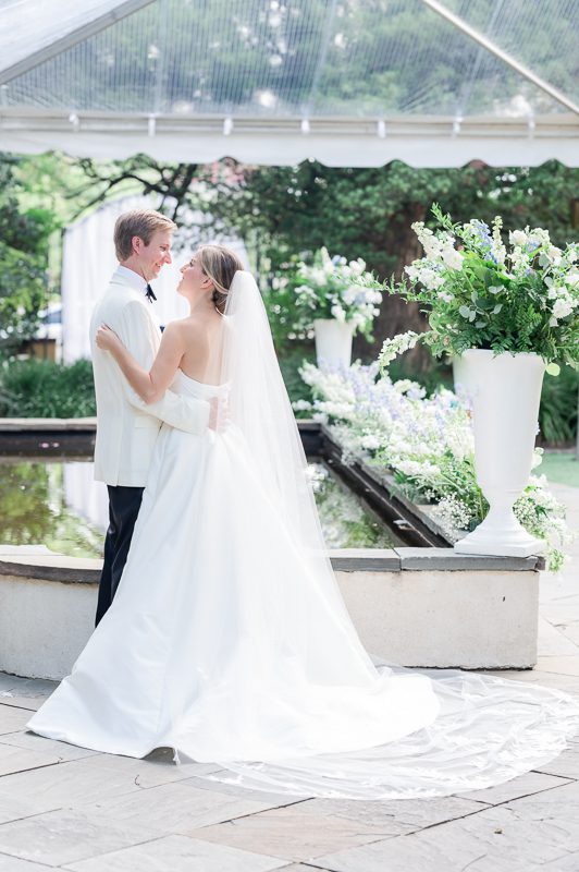 newlyweds hold each other in front of ceremony site at William Aiken House