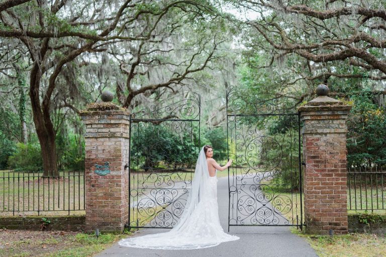 bride holding onto gate at Legare Waring House looking over shoulder