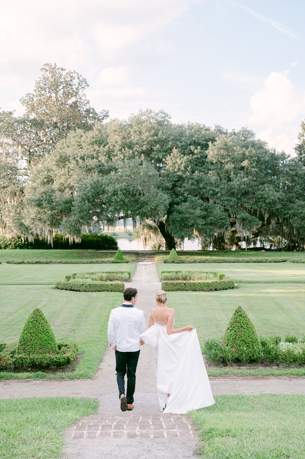 newlyweds walk away towards tiered garden