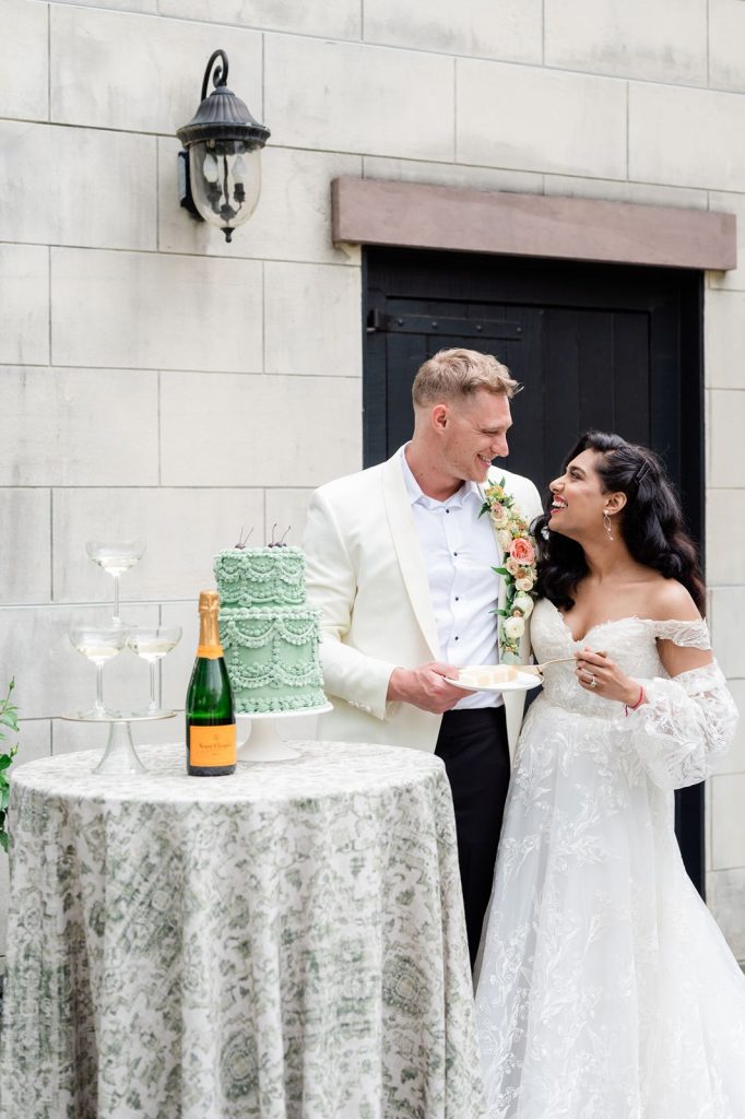 newlywed couple feed each other wedding cake