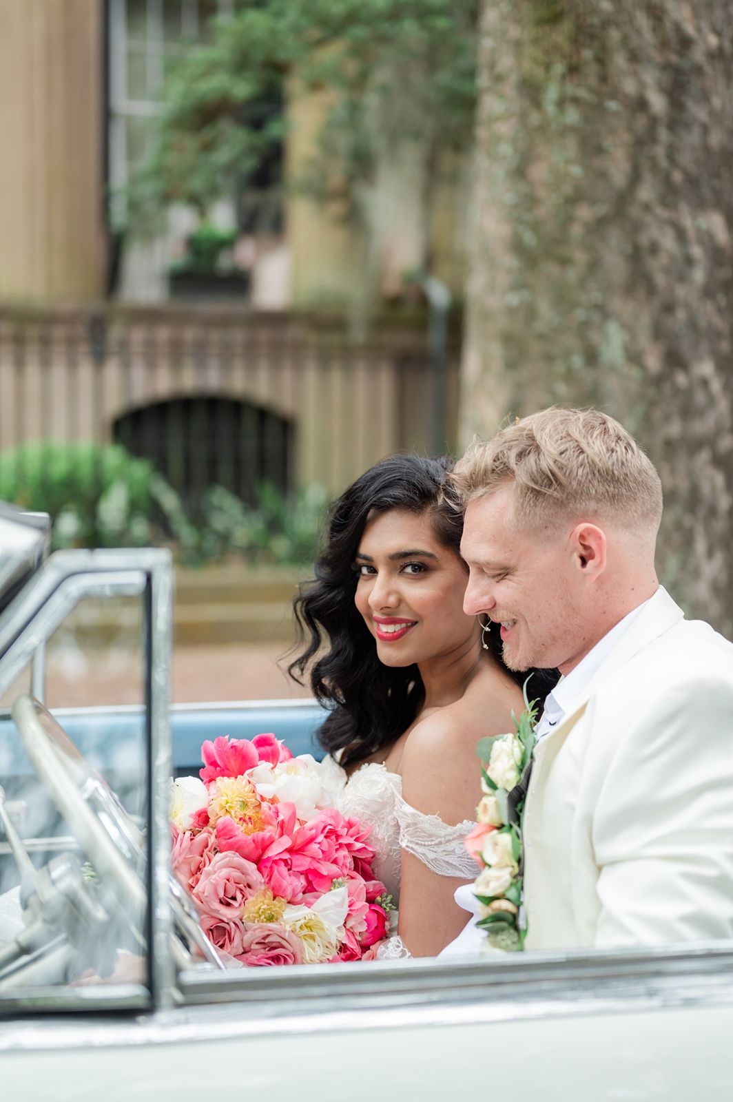 bride and groom seated in vintage convertible