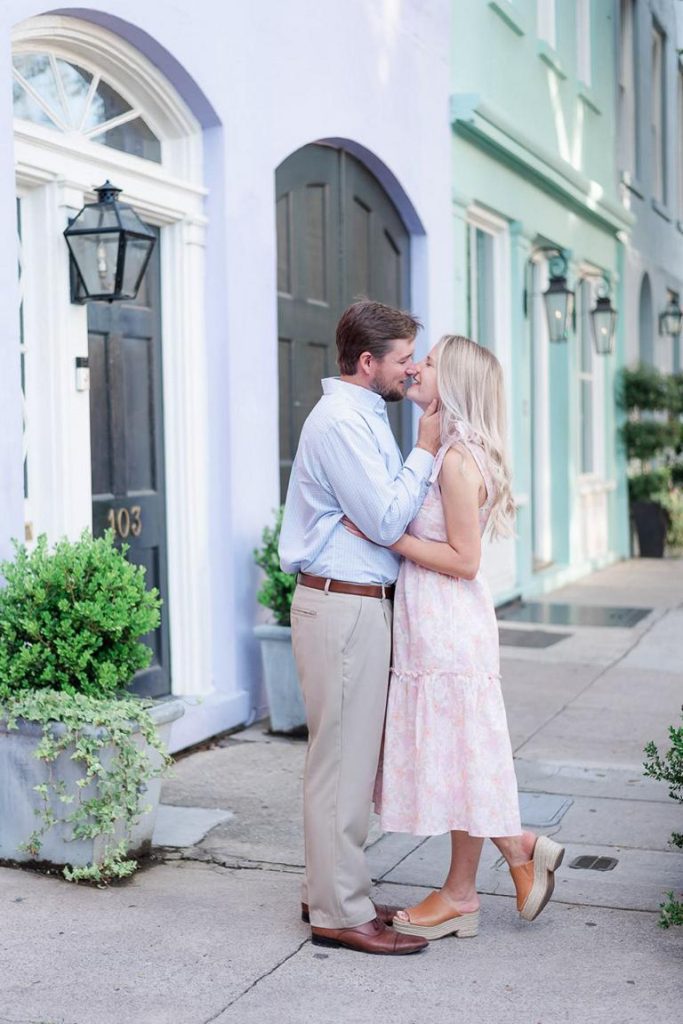 couple kiss in front of rainbow house in Charleston, SC