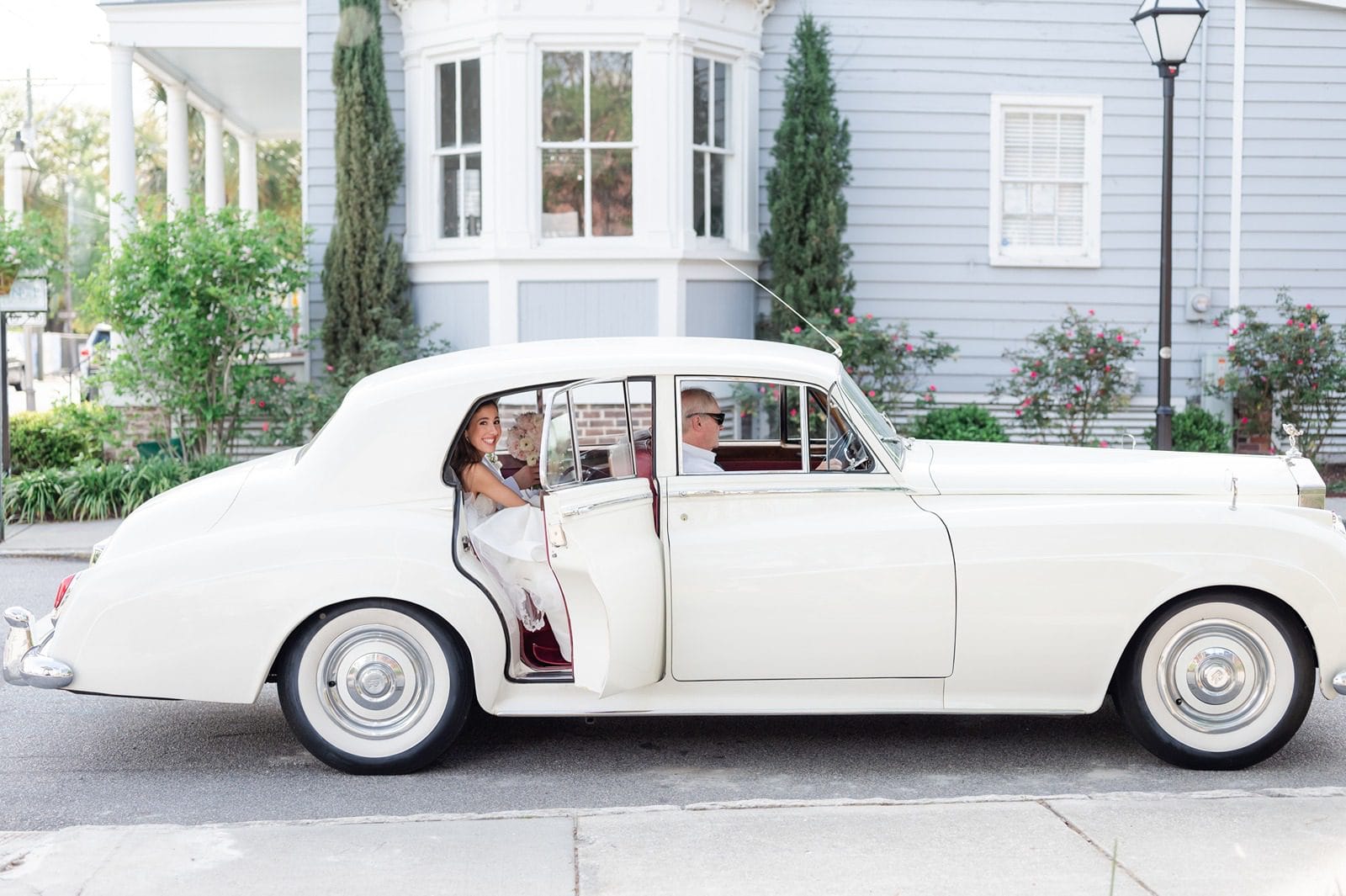 bride stepping out of vintage white Rolls Royce