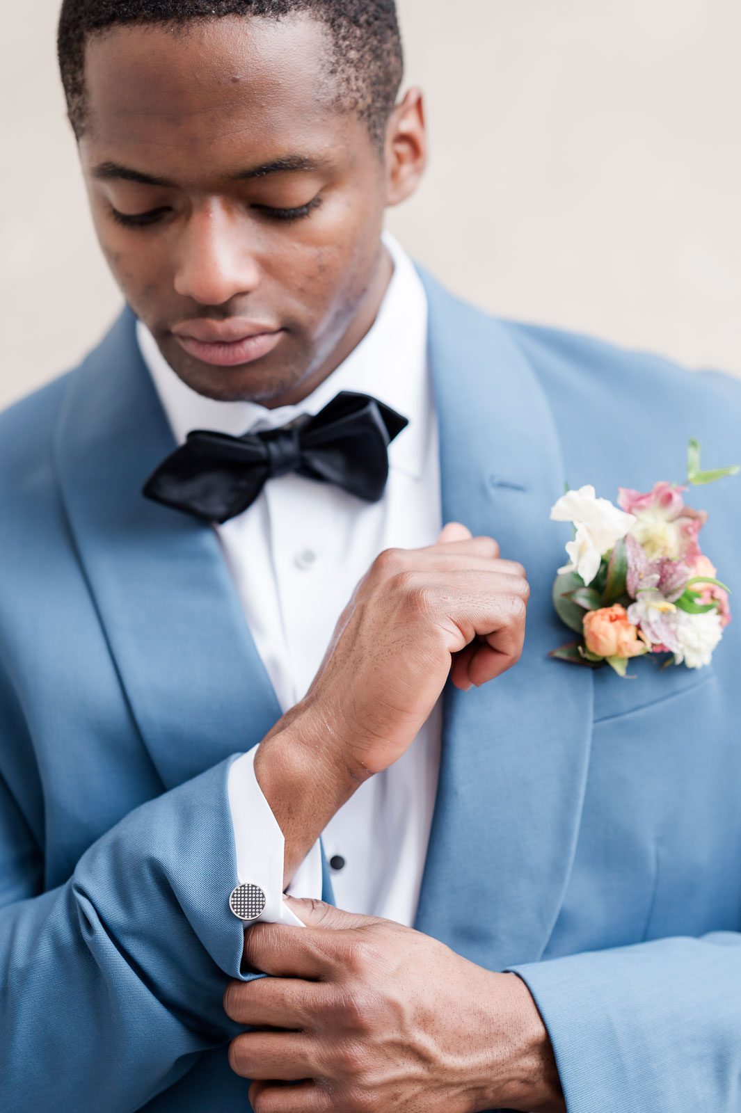 Groom putting in polka dot cuff links