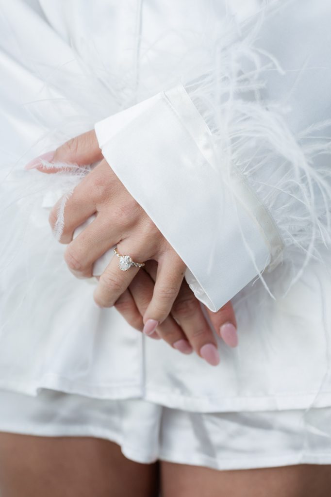 bride folding hands while wearing her pajamas adorned with feathers
