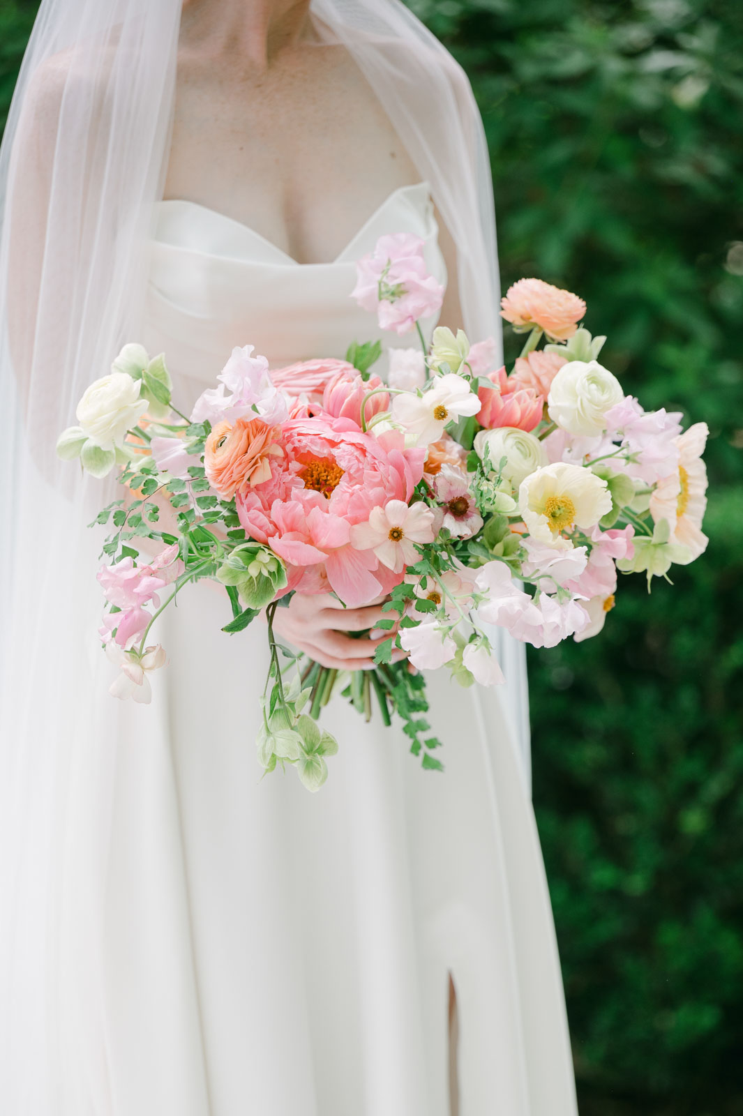 close up of bride holding floral bouquet full of large pastel peonies