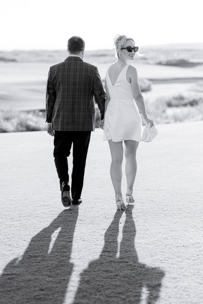 couple walking away hand in hand with bride to be looking over shoulder